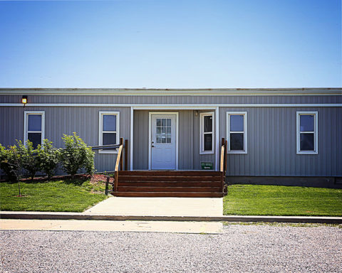 Linn Valley City Hall — a single-story gray building with a covered front entrance and steps.