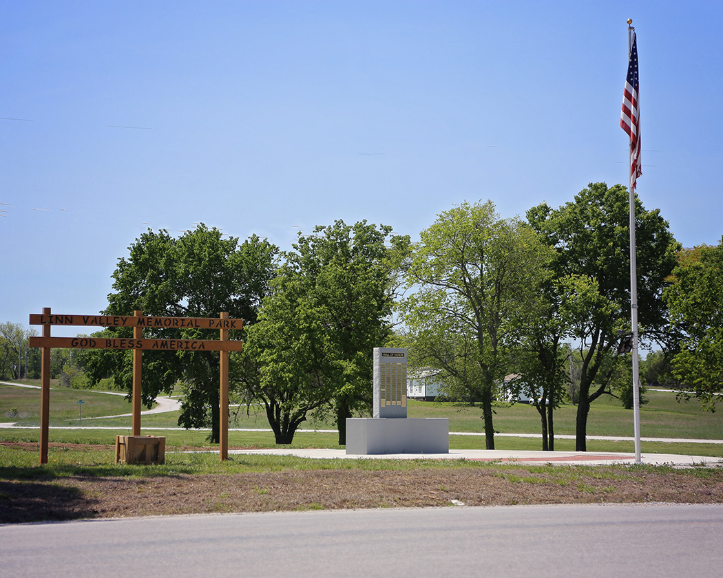 The Veterans' Wall of Honor and "Linn Valley Memorial Park — God Bless America" entrance sign, with an American flag flying at Memorial Park.